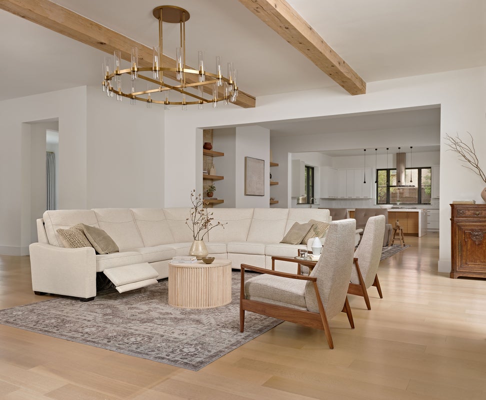 Open media lounge with low-profile motion seating and reclining chairs on a large rug